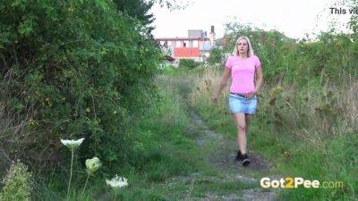 Watch this blonde teen pee in the open field in close-up action - sexu.com